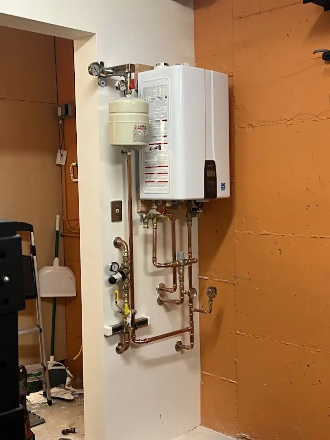 Plumbing technician inspecting water heater connections in Kimberly